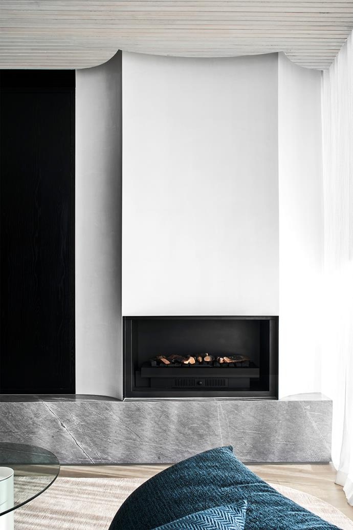 The fireplace surround is clad in St Croix dolomite from CDK Stone against the polished plaster wall.
