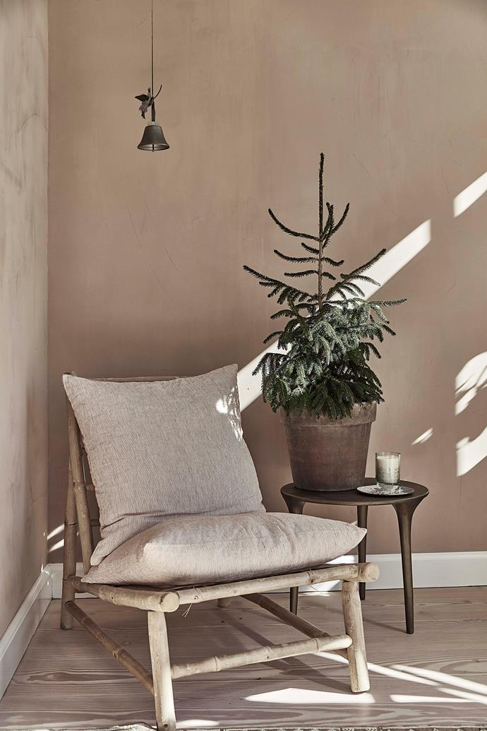 A single bell and a potted pine add a Christmas-y touch to this cosy reading nook.