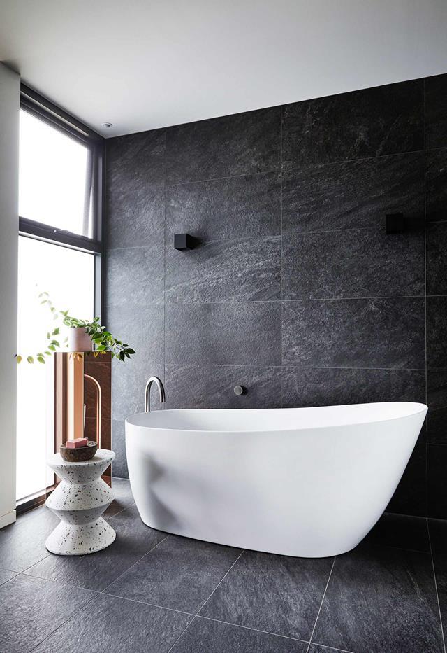 In this [contemporary family house in Torquay](https://www.homestolove.com.au/contemporary-family-house-torquay-22236|target="_blank"), contrast is key. In the ensuite, dark grey tiles create a moody and personal space, which is offset with warm timber and the inclusion of this striking, organic-shaped freestanding bath.