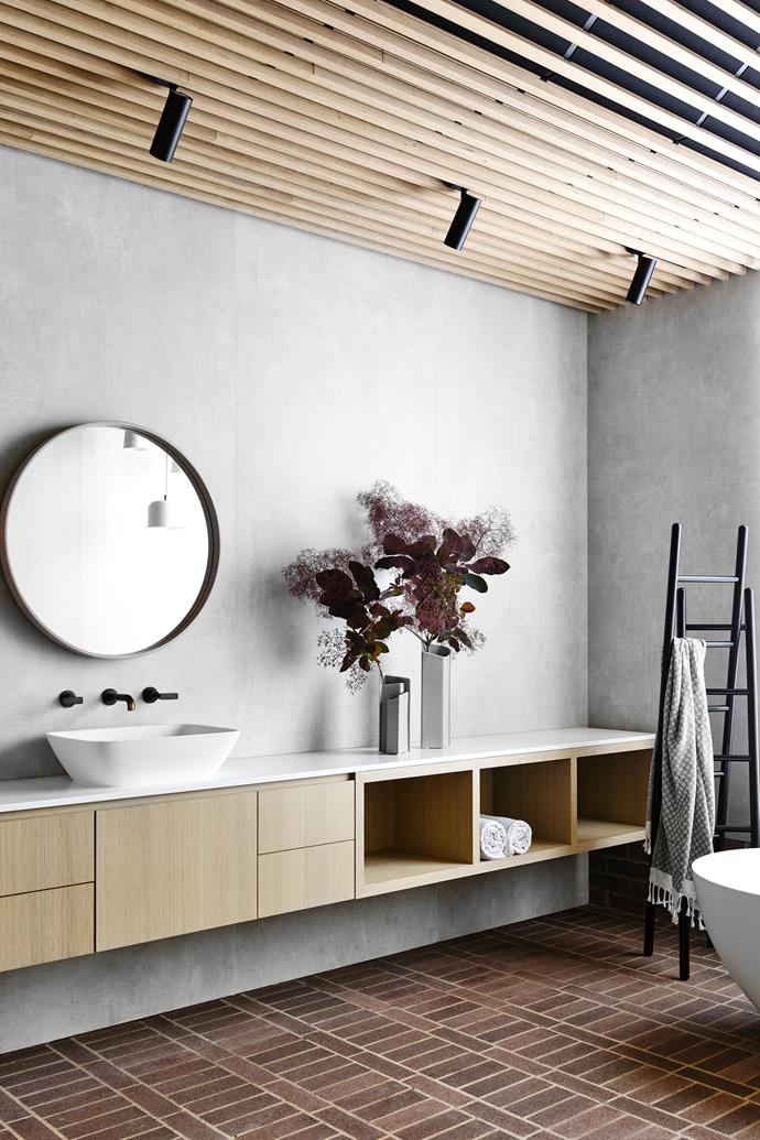 The walls in the main ensuite are finished in porcelain panels from Artedomus. The custom vanity is in Oak Rift White Wash veneer and is by George Fethers & Co. The Ligne Roset 'Cells' vases and the 'Passe Passe' towel rack are from Domo.