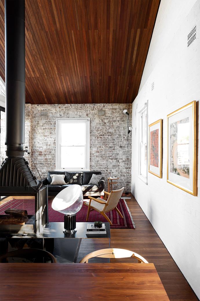 Clever furniture placement defines the eating and sitting spaces, all warmed by a cast-iron [Cheminées Philippe](https://chemphilaust.com.au/|target="_blank"|rel="nofollow") fire to counter the cool, raw nature of the exposed brick walls. Black sofa, owner's. Flos 'Taccia' lamp, [Living Edge](https://livingedge.com.au/|target="_blank"|rel="nofollow").
