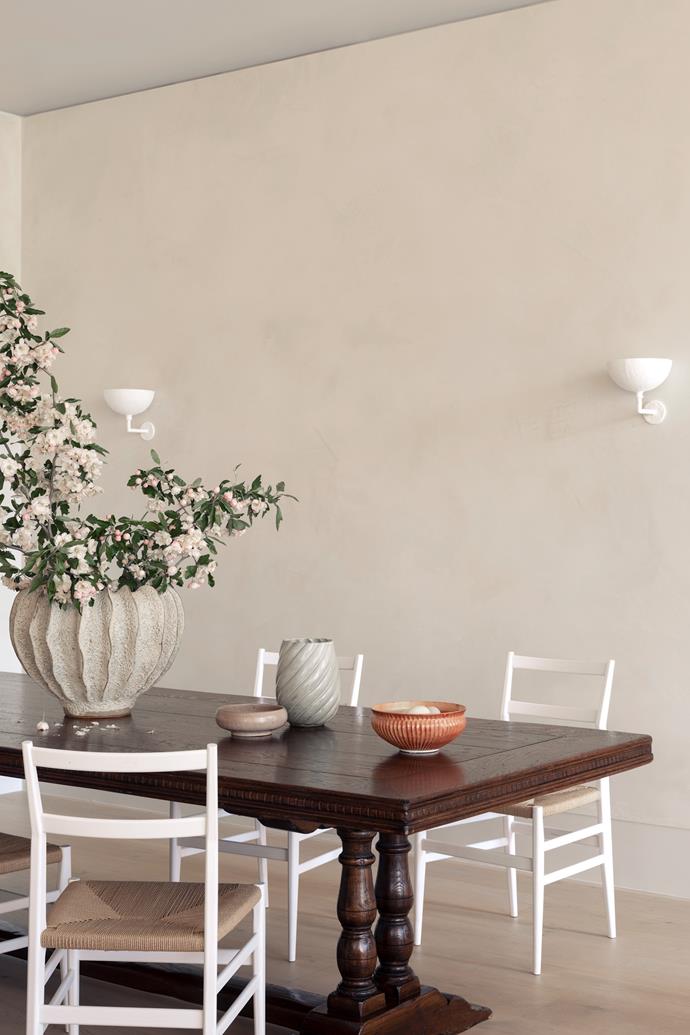 In the dining area, Cassina 'Leggera' chairs by Gio Ponti with antique French table from Sally Beresford. Wall sconces from Anna Charlesworth. Ceramics on table from Planet.