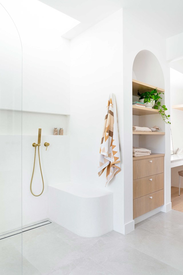 The light, bright finishes in [this crisp, curvy bathroom](https://www.homestolove.com.au/gold-coast-textural-sun-drenched-home-23215|target="_blank") is testament to the fact that shower designs for seniors needn't be ugly and cumbersome. An open plan design with a moulded bench seat allows for comfort and easy access without trip hazards.
