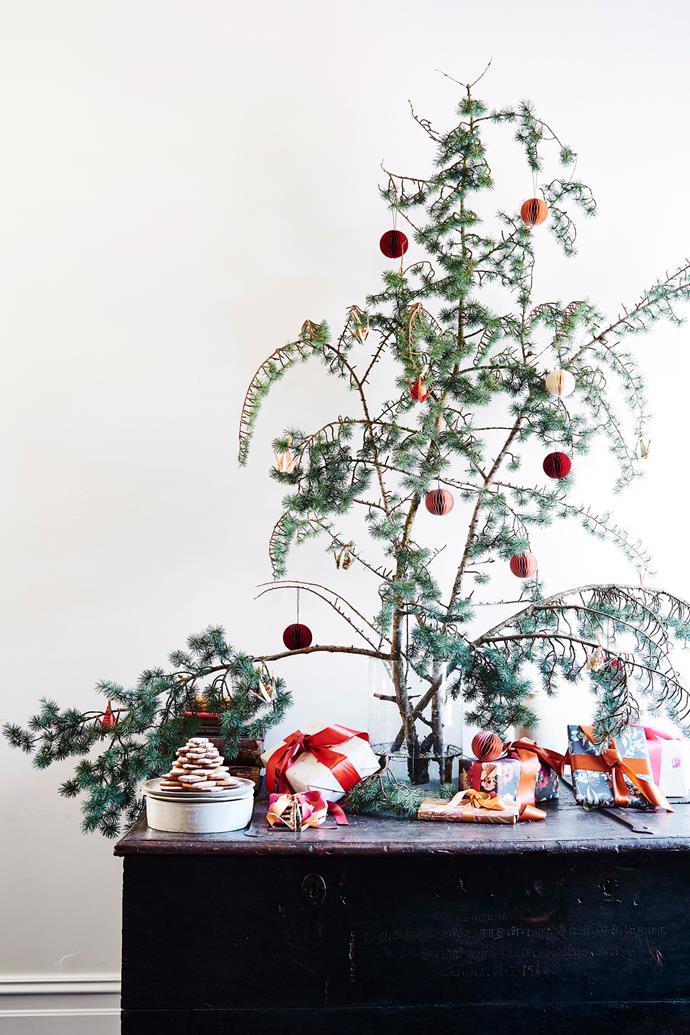 Fill a large vase with tree branches and foliage and decorate them with baubles for an impactful yet cost-effective Christmas display.