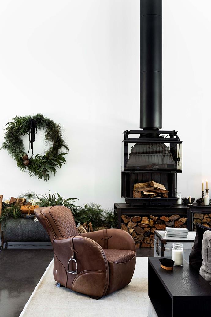 The Cheminees Philippe fireplace, with custom steel plinth and firewood storage, is the "talking piece" of the living room. A vintage French galvanised trunk sits beside the saddle chair by Coco Republic, while the festive wreath is from Porter & Hudson.