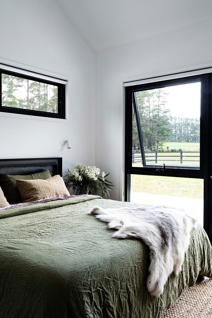 In the bedroom, a custom steel bed frame is topped with Cultiver linen.