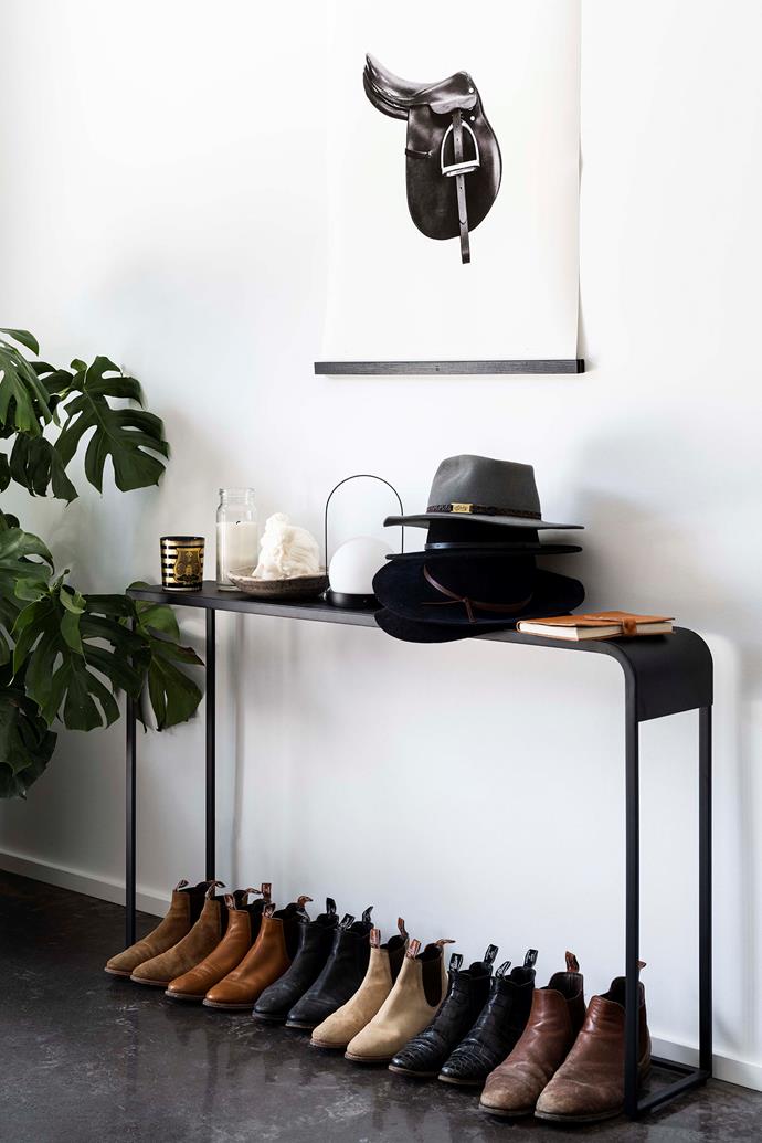 Harold's Saddle by [Calico Pony's Katie Mendl](https://www.homestolove.com.au/home-photography-studio-13959|target="_blank"|rel="nofollow"), with a frame by Good Deeds hangs above well-worn Akubras and work boots.