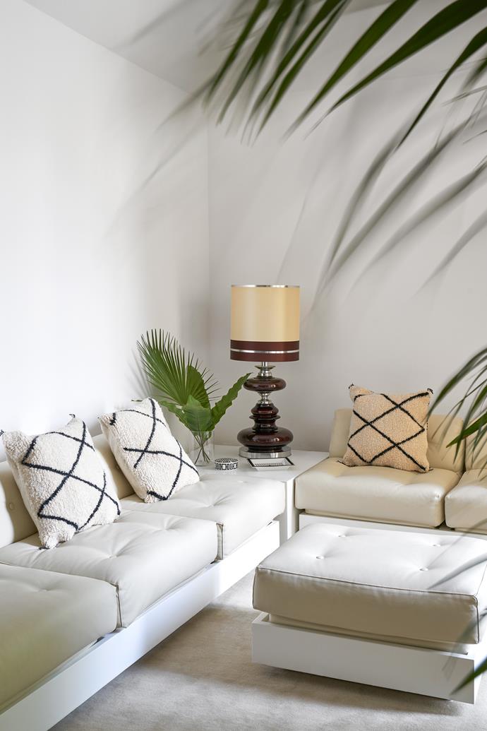 Plants soften the neutral palette in the TV room. "The large sofa, perfect with its pouf, is original from the 1970s and made by Monsani," Barbara reveals. To further soften the minimal scheme, she has accessorised the sofa with Berber tapestry cushions. The table lamp is vintage.