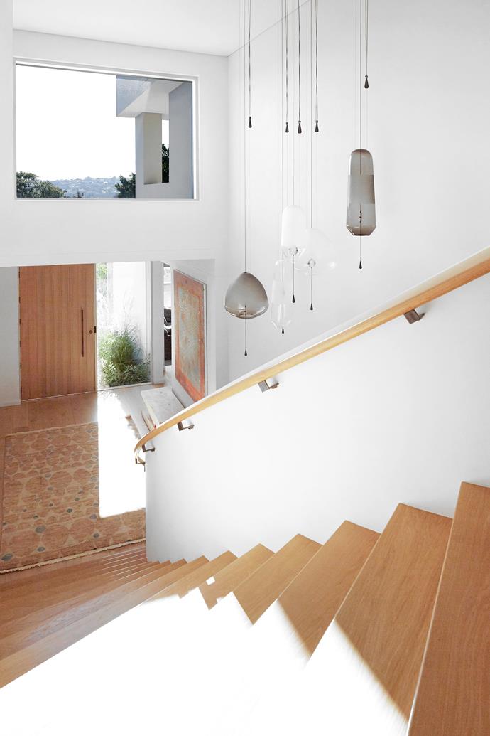 The sweeping curve brings people up to the main living areas. At the bottom of the stairs is a peg-shaped Riva 'Molletta' bench from [Fanuli Furniture](https://www.fanuli.com.au/|target="_blank"|rel="nofollow"). Vantot 'Limpid' pendant lights, [Spence & Lyda](https://www.spenceandlyda.com.au/|target="_blank"|rel="nofollow"). Stevie rug in Camel, [Jardan](https://www.jardan.com.au/|target="_blank"|rel="nofollow"). Artwork (above bench) by [Marisa Purcell](https://www.marisapurcell.com/|target="_blank"|rel="nofollow").