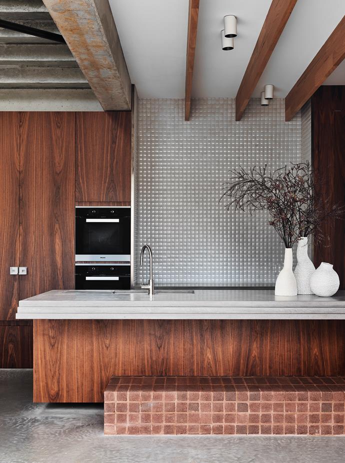 Rugged raw finishes deliver a stylish but low-maintenance interior at [this robust Mornington Peninsula home](https://www.homestolove.com.au/robust-home-mornington-peninsula-22602|target="_blank"). The kitchen features a hand-trowelled concrete bench, concrete joinery handles, and American walnut veneer on the cupboards. 