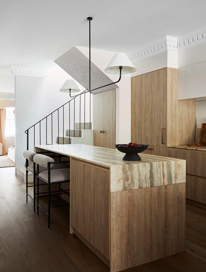 [This elegant Sydney home has French-inspired interiors](https://www.homestolove.com.au/elegant-home-french-inspired-interior-sydney-22184|target="_blank"), which translated to a bespoke iron pendant light and oak veneer cabinetry in the kitchen. The decorative cornice detail was designed by interior architect Phoebe Nicol.