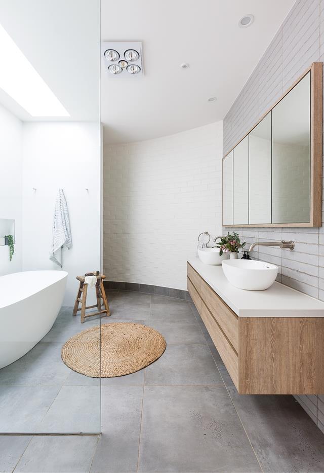 **Beachside bliss**<Br>
A curved brick wall at the front of the home (designed to hide the front door from the street) makes a shapely statement in [this family bathroom](https://www.homestolove.com.au/palm-springs-new-build-sydney-22838|target="_blank"). "The bathroom sits here as it didn't require a window," says homeowner Heather. Instead, a large skylight invites natural light in, while an extra section of wall hides the toilet – a practical feature in a large, open wash zone.