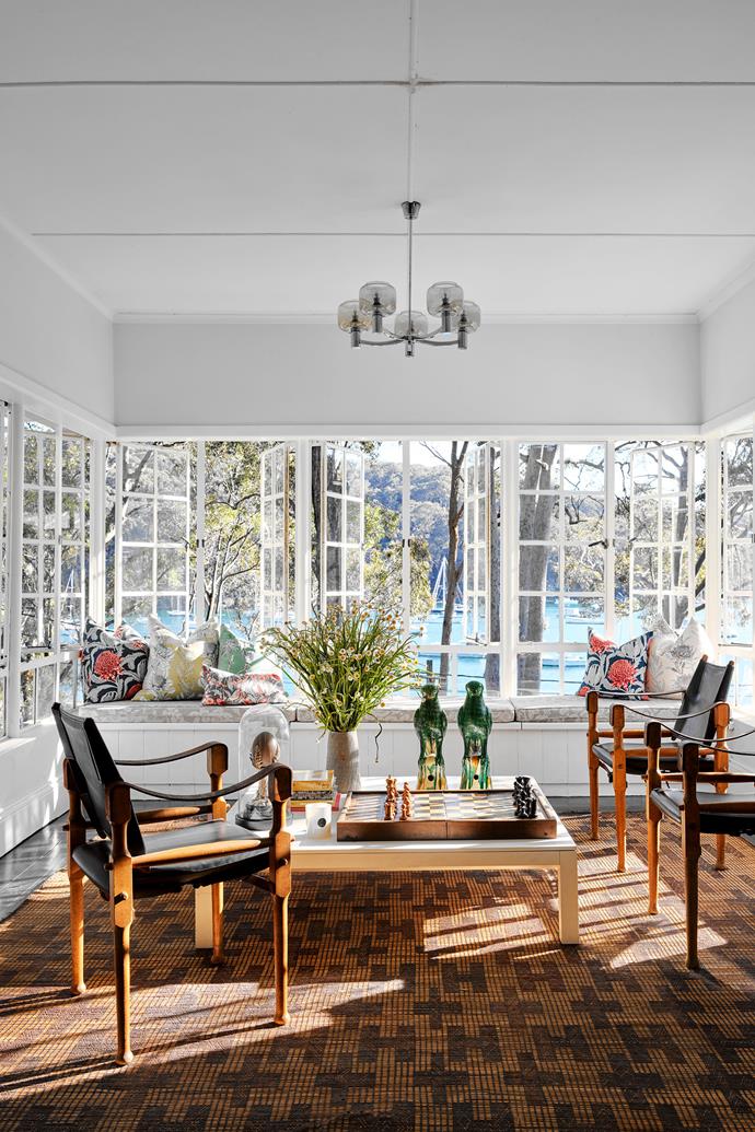 Taking in tranquil water views, the sunroom of [Ventnor: One of Sydney's oldest homes](https://www.homestolove.com.au/sydney-oldest-home-ventnor-renovation-23259|target="_blank"), hosts a grouping of Michael Hirst timber and leather safari chairs surround the vintage Minotti coffee table atop a patterned rug handwoven by Tuareg artisans.