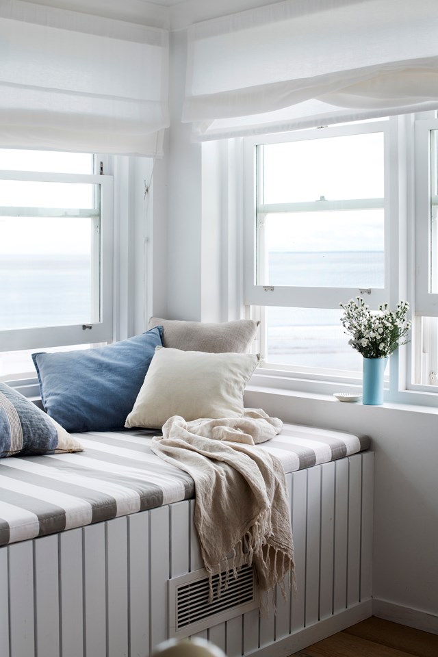 Designed to cleverly conceal an air-conditioning duct, with a view such as [this beach house window seat](https://www.homestolove.com.au/hamptons-beach-house-gerroa-23265|target="_blank") boasts, there's little to be done in the decorating stakes. Simple window dressings and cushions are functional, toned down to a calming coastal palette.