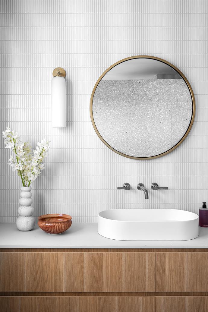 The wall light hanging in the main ensuite is from Articolo Lighting, the mirror from West Elm and the tapware from Brodware. In the mirror, you can see the reflections of the beautiful terrazzo feature wall tile above the bath.