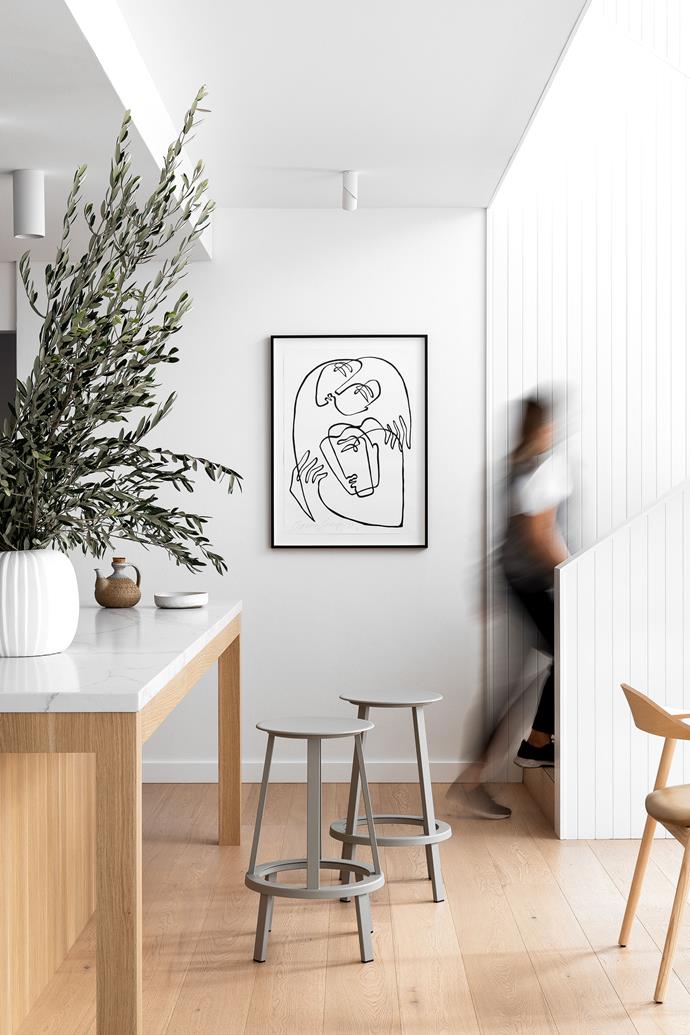 The kitchen flows seamlessly into the dining room and up the stairs to the rest of the house. "Even though it's quite a large house, we all feel very connected," says the homeowner. Artwork by Octavia Tomyn.