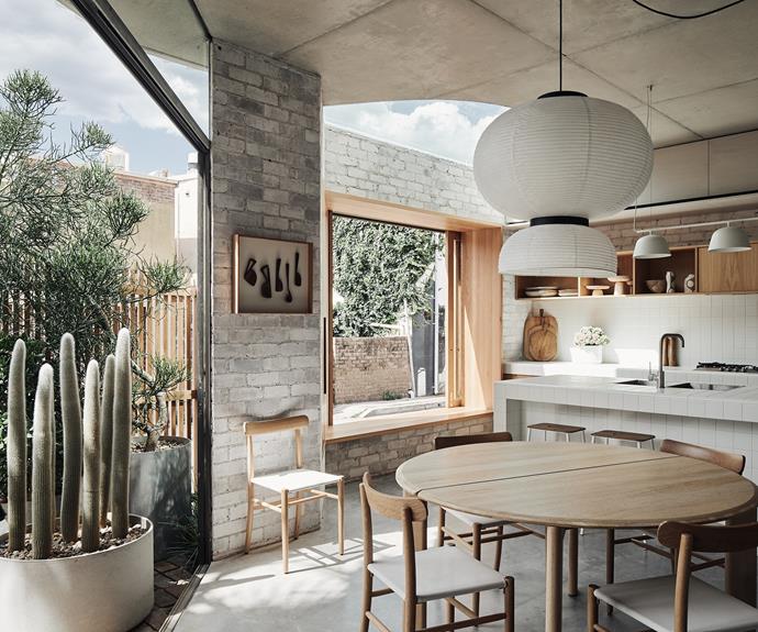 The timber-clad kitchen opens out to multiple outdoor spaces, with pocketed skylights filtering in the sun.