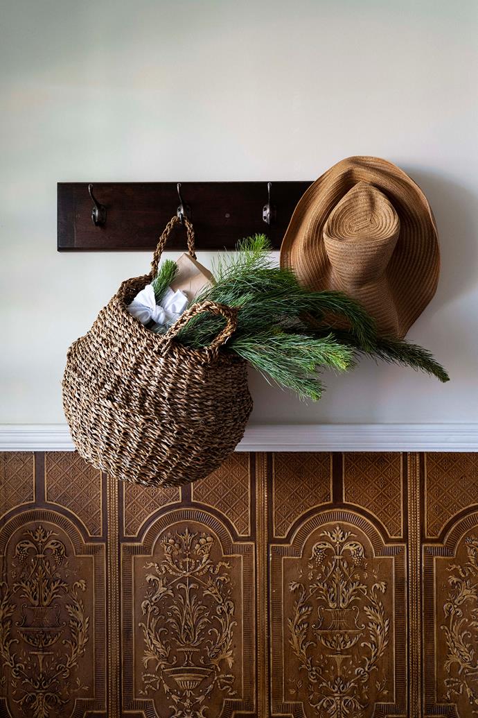 Coat hooks in the entrance way are used for baskets and hats.