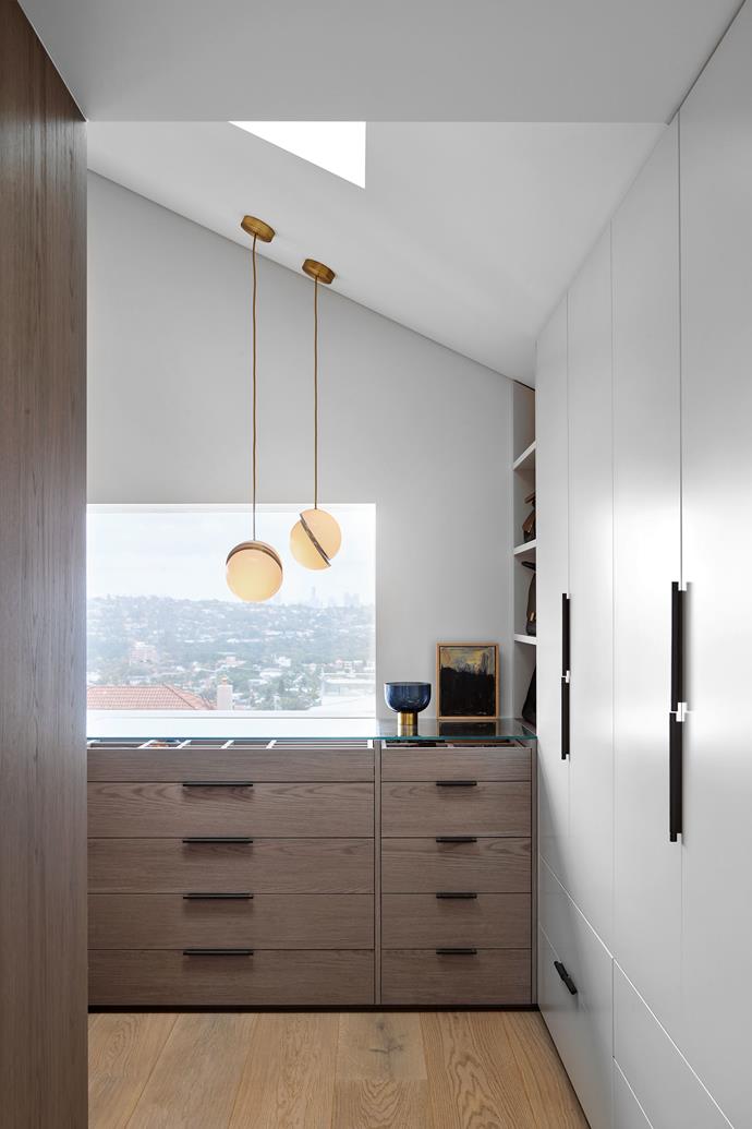 Joinery in the walk-in robe is Cellupal timber veneer from George Fethers. Leather recessed pull handles from MadeMeasure. Lee Broom 'Mini Crescent' pendant lights from Space.