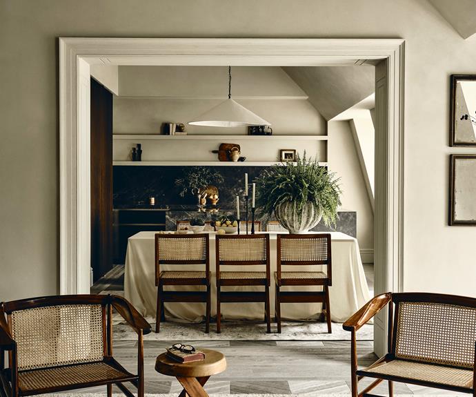 Easy chairs by Joaquim Tenreiro and dining chairs by Pierre Jeanneret create visual continuity between the living and dining spaces. Distressed mirrors add to the perfectly imperfect country charm.