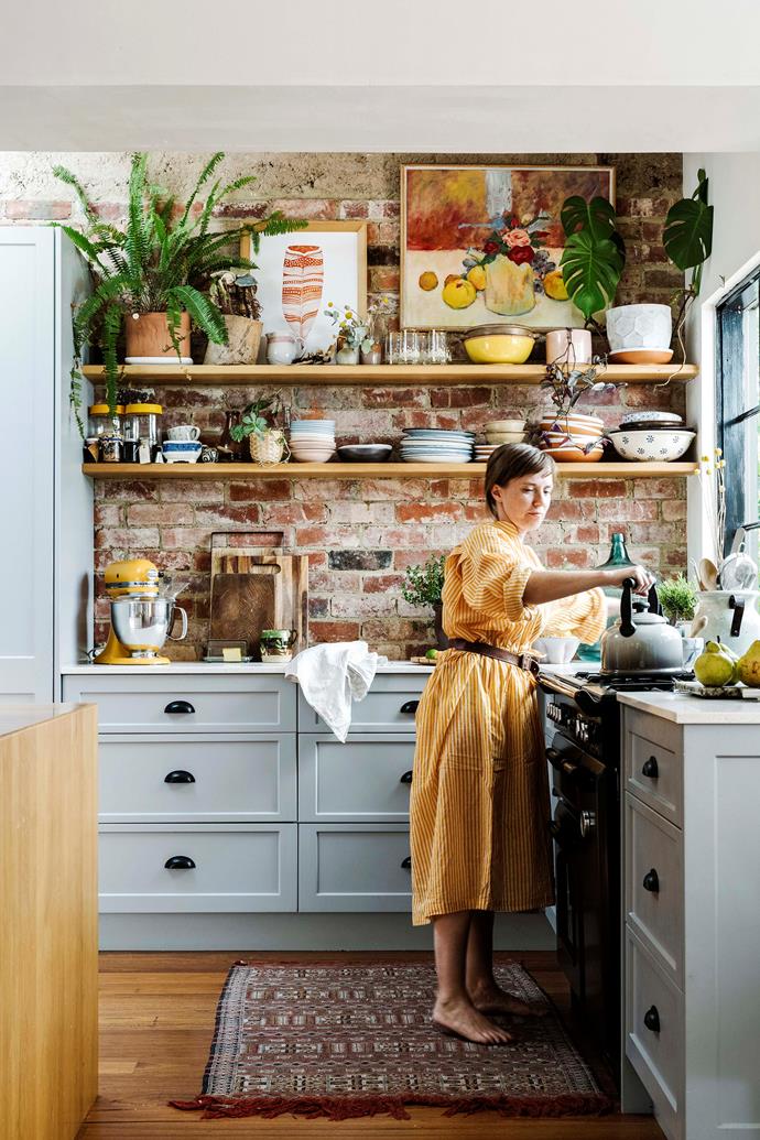 "We love open shelving as it's more room to display treasures," says homeowner Emma, of her eclectic shaker-style country kitchen. "For me, a kitchen has to have art, lamps and flowers. Everything I touch has to be really nice, whether it's old wooden spoons or mismatched crockery," she adds.