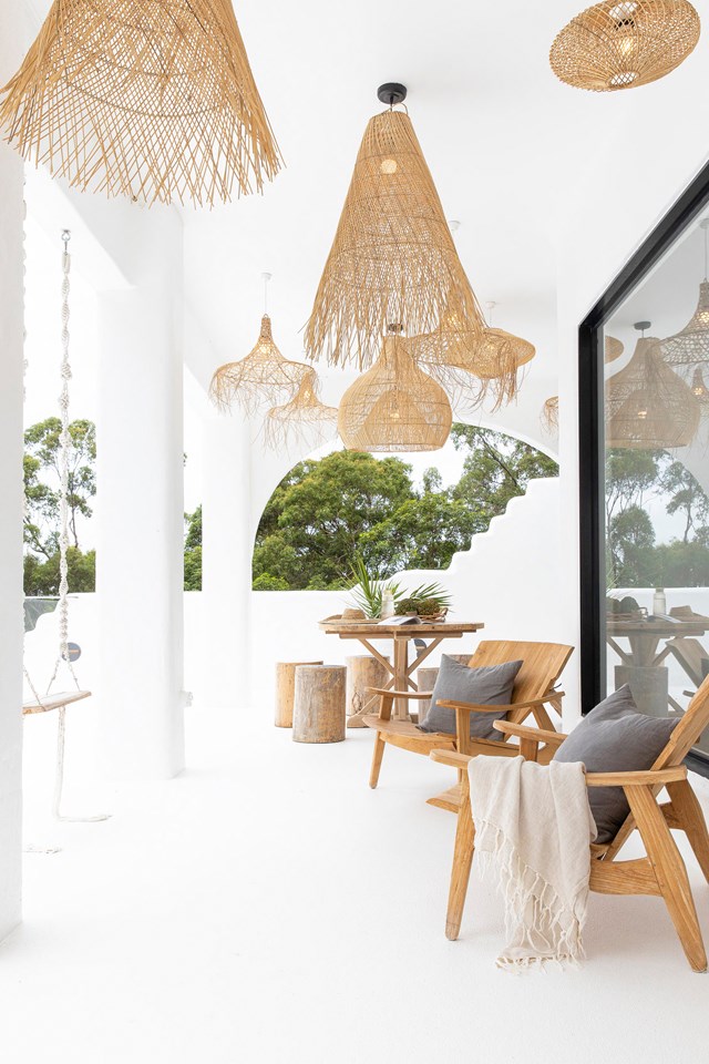 Adorned with a mix of rattan pendants, this terrace is a favourite spot to relax. Awash in white, timber furniture warms up the space, including the resourceful use of a fallen tree on the property to make log stools, which feature [throughout the house](https://www.homestolove.com.au/natural-mediterranean-style-home-noosa-23302|target="_blank").