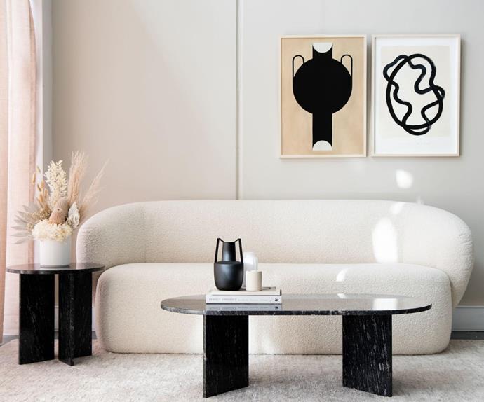 Monochrome living room featuring a curved, boucle sofa and contemporary furniture