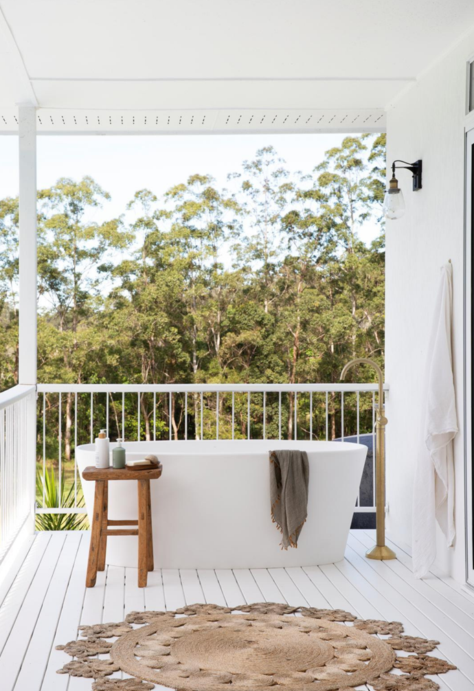 A private bathtub on the back deck overlooking a sea of trees is the epitome of tranquillity at [this expansive Noosa home](https://www.homestolove.com.au/white-on-white-coastal-home-noosa-22415|target="_blank") with white on white interiors.