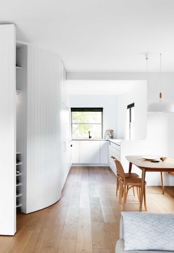 A minimalist makeover of [this Sydney apartment](https://www.homestolove.com.au/minimalist-makeover-sydney-makeover-16703|target="_blank") granted a fresh start for a pair of almost-empty nesters. The curved wall was cleverly crafted out of tongue-and-groove lining boards with concealed hinges to mask over the storage inside. 