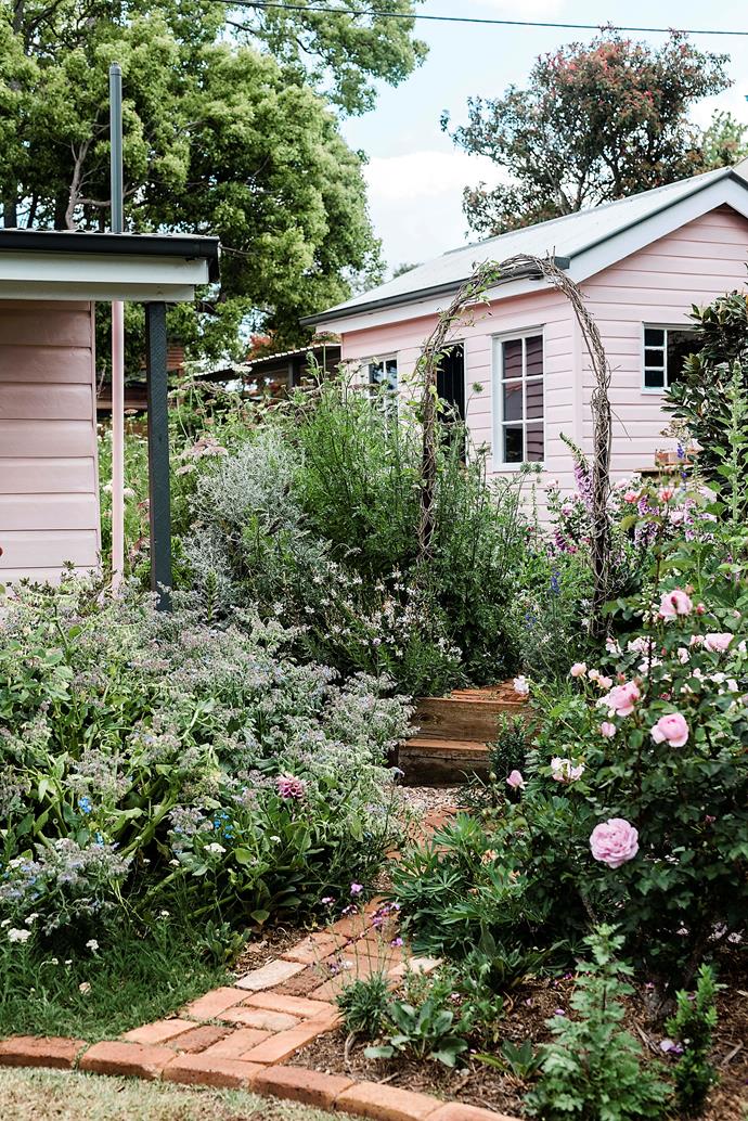 The rambling garden of [this quintessential cottage in Toowoomba](https://www.homestolove.com.au/norwood-roses-garden-toowoomba-qld-22954|target="_blank") spills out over the path leading to a shed that has been refurbished with weatherboard panels and stained-glass windows from local salvage yards. "I just wanted it to be full and lush, and for every area to be beautiful," says the owner Caitlyn Mason.
