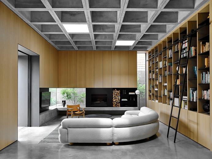 Extensive built-in bookshelves in the informal living area were backed with a special felt for acoustic control. [The curved 'Valley' sofa](https://www.homestolove.com.au/curved-furniture-trend-2019-19737|target="_blank") is from Jardan, 'Spanish' chair in oak and leather by Børge Mogensen is from Great Dane. In the far right corner stands a Flos 'IC' floor lamp by Michael Anastassiades from Euroluce.