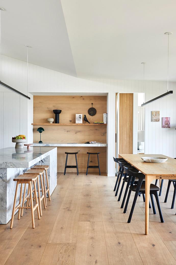 Drawing inspiration from the coastal landscape, natural materials cool stone and warm timber act as a clean and neutral blank canvas in the family-friendly kitchen. The Sketch 'Odd' bar stools in Light Oak (at the island bench) and Black Onyx (work nook) are from [GlobeWest](https://www.globewest.com.au/|target="_blank"|rel="nofollow"). Dining table and chairs, existing pieces belonging to the couple.