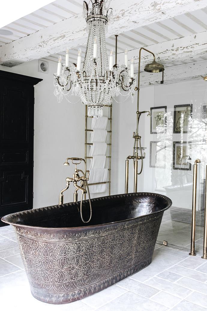 A spectacular Empire-style 12-arm chandelier from Italy hangs above a Rajasthani bronze bath with incised line work in the master bathroom. Custom brass fittings from The English Tapware Company. Louis XVI armoire in black walnut with panelled doors and cast-iron hardware.