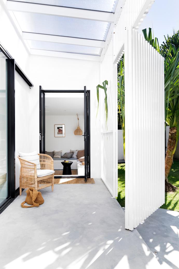 **ENTRANCE** Rather than a designated front door, the home's entrance is a series of pivoting batten screens, which open to reveal doors leading to the playroom and living area. The Malawi chair is from Uniqwa.