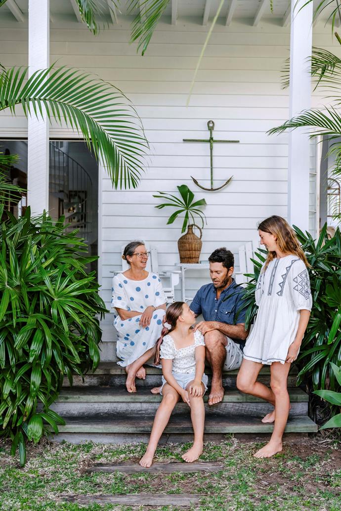 The family on the verandah, which is surrounded by palms.