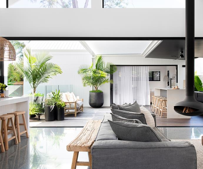 Though it's only used in winter, the Zen Elegante suspended fireplace looks great in this space all year round. Many pieces — the Hendrix modular sofa and ottoman, the Uniqwa Furniture 'Tamale' munggur-wood coffee table and Annika outdoor bar stools — are from [Village Stores](https://villagestores.com.au/|target="_blank"|rel="nofollow"). Orissa jute and wool rug in Grey/Natural, [Freedom](https://www.freedom.com.au/|target="_blank"|rel="nofollow"). Black vessel and Concrete Arch II by Natalie Rosin, [Kira & Kira](https://kiraandkira.com.au/|target="_blank"|rel="nofollow"). Outdoor benchtop, Caesarstone Primordia.