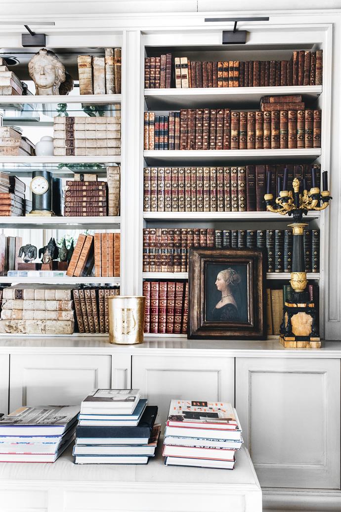 In the dining room, a collection of antique books with vellum borders, including titles from the 17th century to the Napoleonic era, are housed in painted bookcases with mirrored backs.