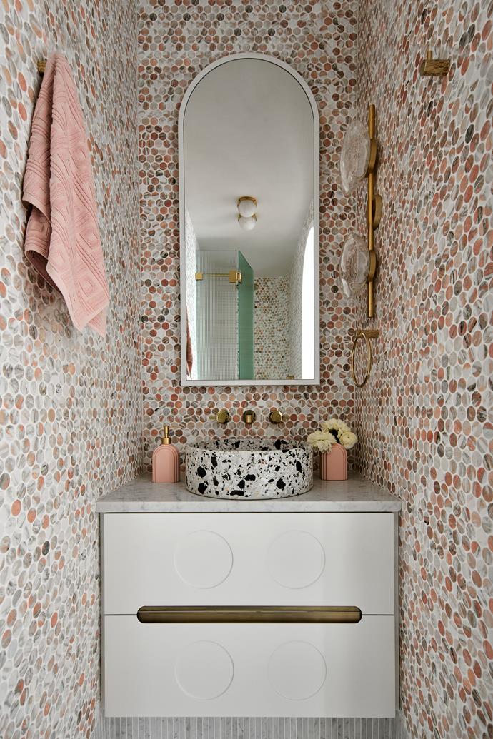 The ensuite has 'Penny Round' mosaic tiles in Norwegian Rose from Teranova. Bentu 'Hui' terrazzo basin from Remodern. 'City Que' wall set in polished brass from Brodware. 'Ceto' double wall light from Ross Gardam.