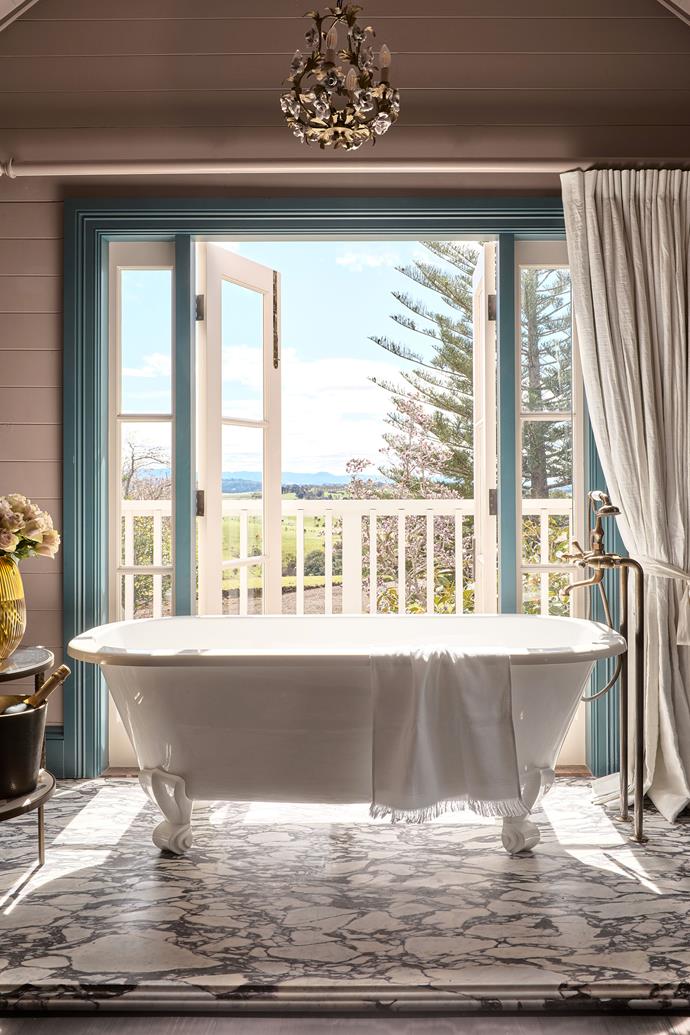 The bathroom in the loft suite is open plan with views out to a magnolia tree and the ocean. Demarcating the bath from the sleeping area is a small platform of [Calacatta Viola](https://www.homestolove.com.au/viola-marble-trend-23175|target="_blank") from Granite & Marble Works on the floor. Victoria & Albert 'Richmond' bath with Astra Walker 'Olde English' floor- mounted mixer and hand shower in aged brass.