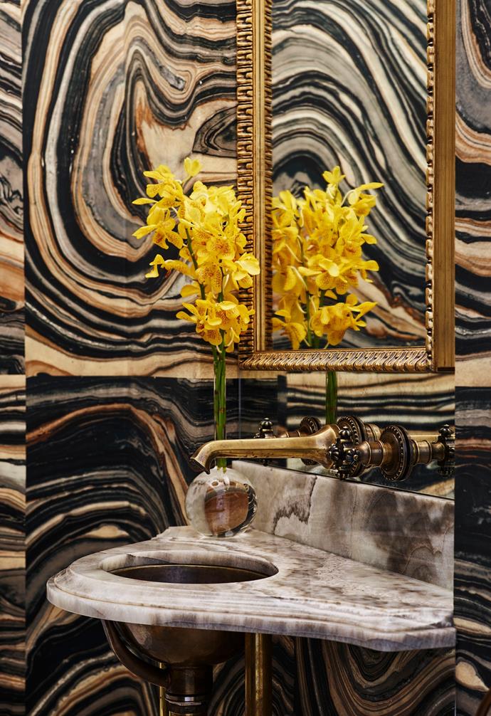 Filled with extravagant details, the powder room of [this glamorous reimagined historical Sydney terrace](https://www.homestolove.com.au/glamourous-heritage-terrace-sydney-23046|target="_blank") has 'Swirls' wallpaper in Green Black from Robert Crowder & Co, California. 

