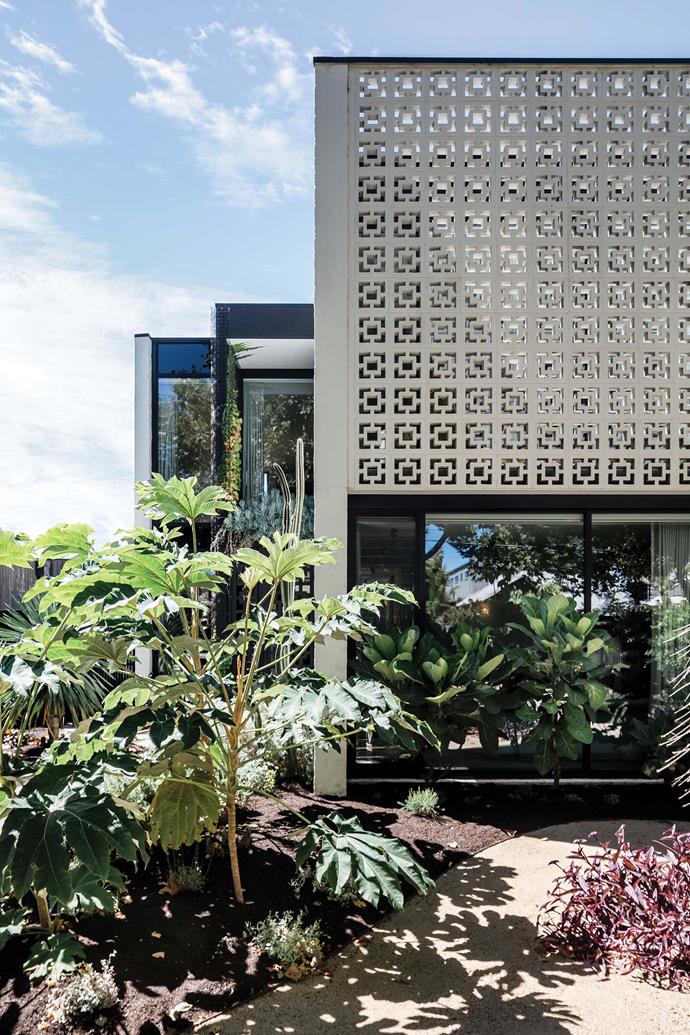 The property stands as a structural continuation of itself, bookended by perforated breezeblock panels.
