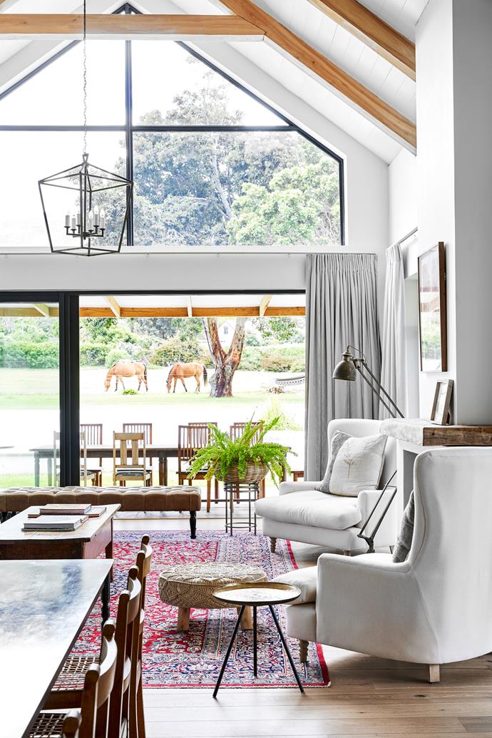 When their attention turned to renovating their 1980s home three years ago, architect Alex Stewart created a space that showcases the outdoors from every turn. The vaulted ceiling in the living room is a nod to [country barns](https://www.homestolove.com.au/barn-style-houses-21208|target="_blank") without being overtly rustic, while the window above the sliding doors lets afternoon light stream in and puts Amber's ponies in the frame. For similar armchairs, try the Amsterdam sofa chair from Xavier Furniture, while the Le Mans pendant light from Hamptons Home evokes the timeless style seen here.