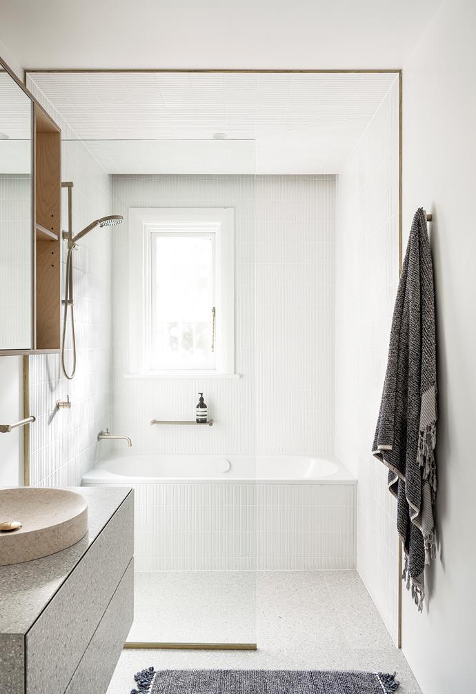 A brass frame and shower screen separate the bathroom into 'wet' and 'dry' areas.
