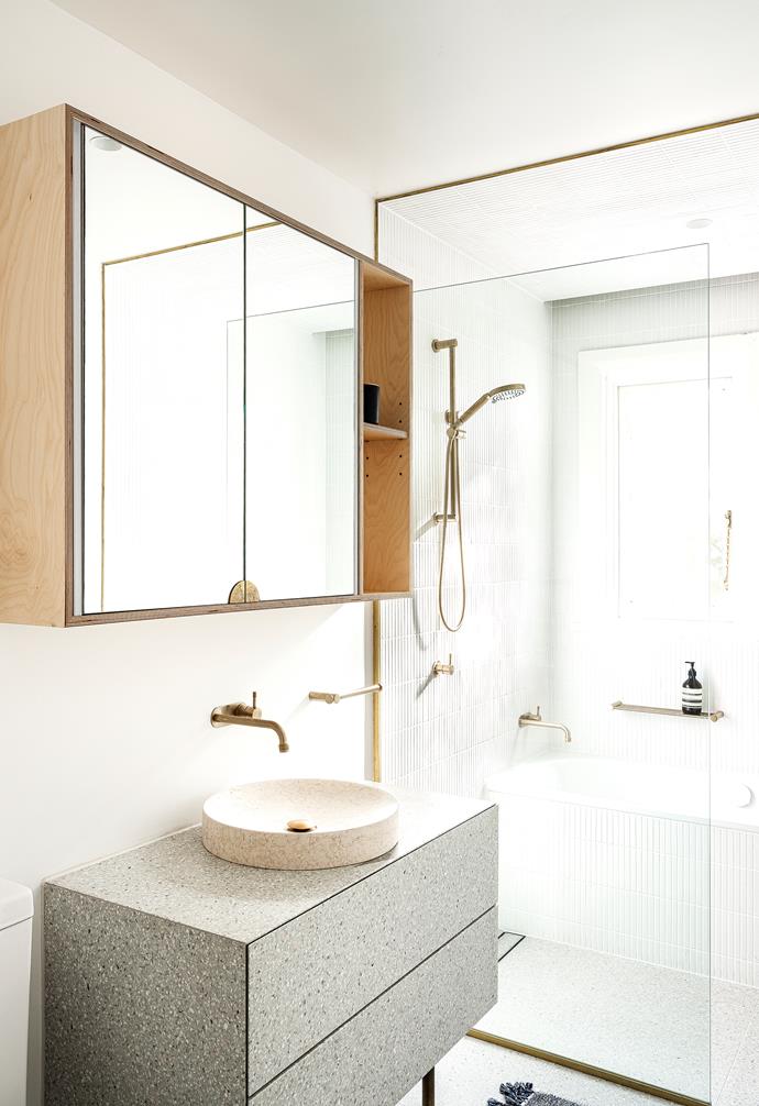 "Treating the walls differently makes it feel like two spaces, giving it the illusion of a bigger bathroom," says Davin. Nagoya tiles run around the bath, up the walls and ceiling. A matte basin and vanity add contrast.