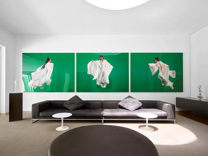 A dramatic triptych by Isaac Julien, Green Screen Goddess (Ten Thousand Waves), 2010, Ultra Endura photograph dominates the family living room. B&B Italia 'Dadone' sofa and 'Harry Large' ottoman in leather, both from Space. Knoll 'Tulip' tables by Eero Saarinen from De De Ce. On the credenza is Caroline Rothwell's The Law of Unintended Consequences I, 2007, in nickel-plated metal alloy from a series of six works.