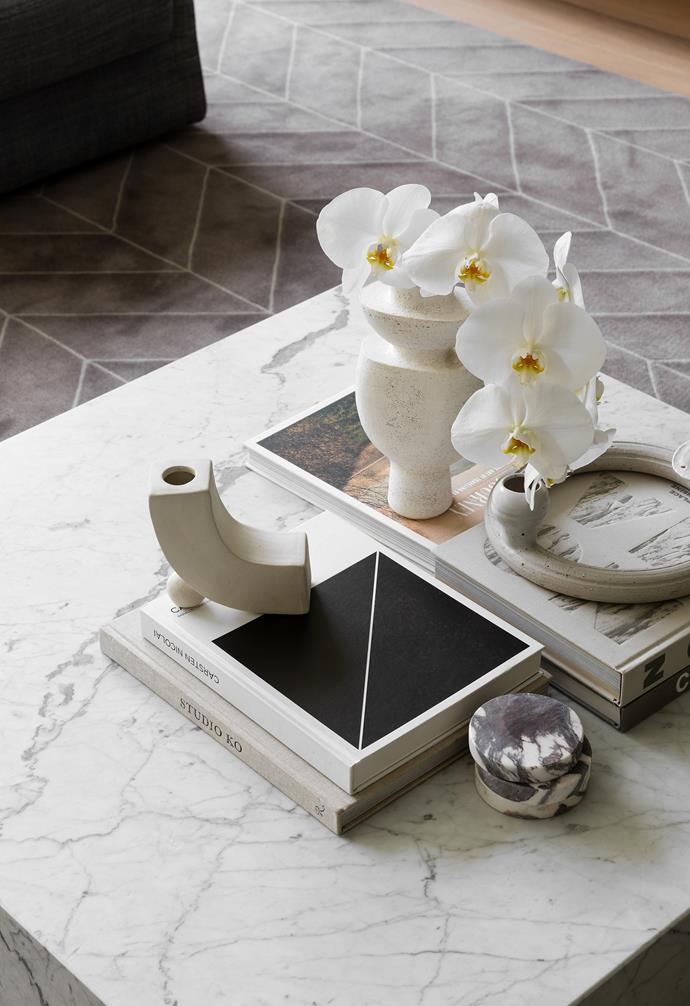 Adele's Carrara marble plinth in the living room is the ideal backdrop for a collection of ceramics and plays off the pattern of the custom rug. "We used a square, plinth-style coffee table as the centrepiece," Adele says. "It brings in the stone from the kitchen, so that everything feels balanced. The crisp white looks great against the dark custom rug. The plinth also sits low and it doesn't feel like you are running around it and doesn't enclose the space. It's an artwork in itself."