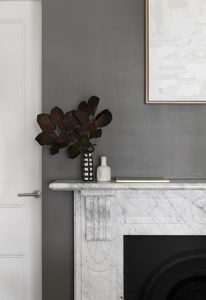 The traditional-style fireplace in a front bedroom reveals marble's versatility. The artwork by Christopher Vine and black-and-white vase from Modern Times are excellent accompaniments. The other vase was found on travels in Greece.