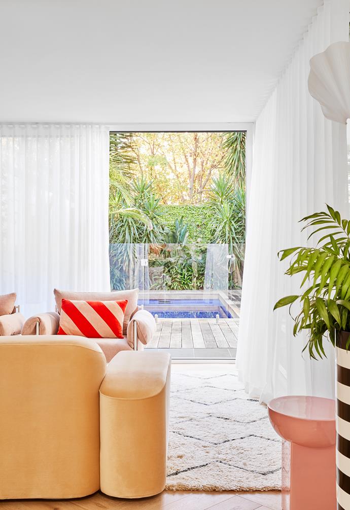 The second living room, with its white Soft Studio curtains and garden views, was designed for quieter moments. To give the space its own feel, Kirsten and Kristel selected a sofa and armchairs by Sarah Ellison. The throw cushion from House of Orange adds a pop of colour and personality.