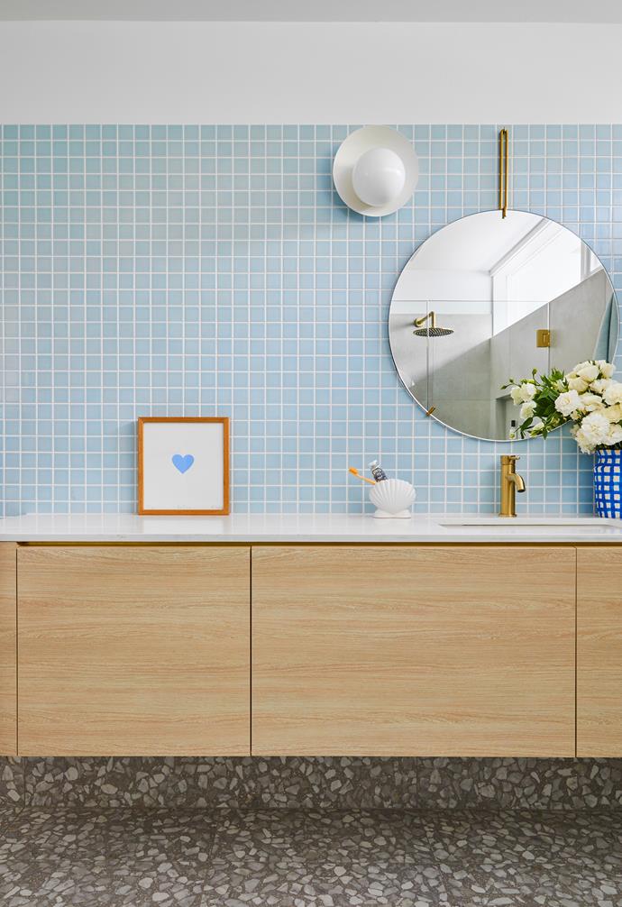 Blue mosaic wall tiles from Artedomus and Marazzi Ghiara flooring by Design Precinct create a cool and airy atmosphere in the bathroom. A slab of Calacutta Nuvo marble from Ceasarstone tops the custom vanity.
