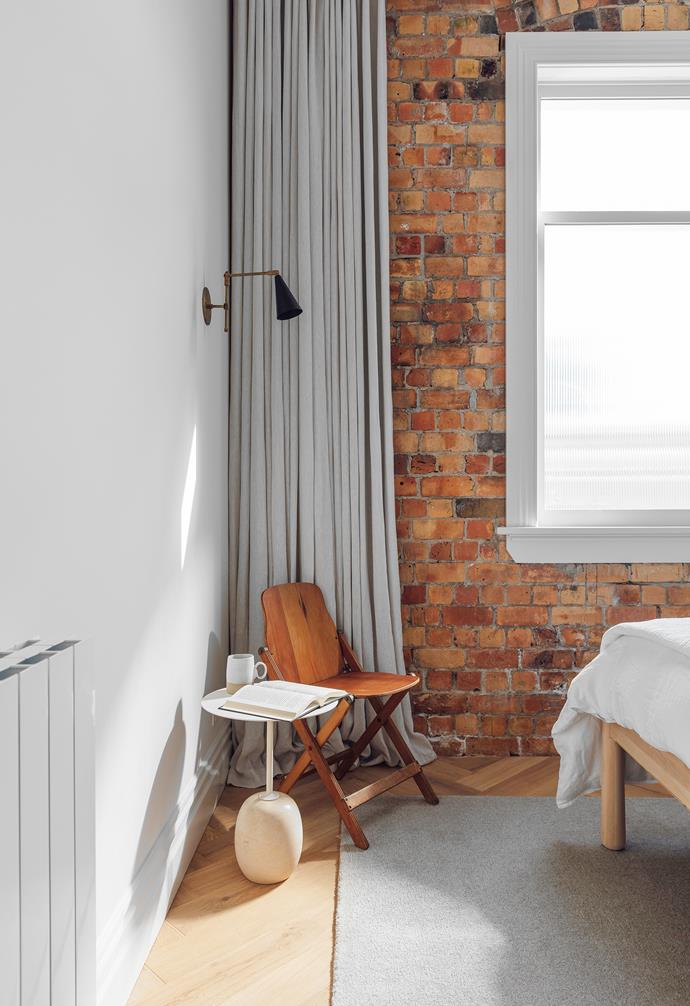 Against the original brick wall, curtains in Kyoto linen from [James Dunlop Textiles](https://jamesdunloptextiles.com/|target="_blank"|rel="nofollow") lend a gentle warmth. A RaraForma lamp sits on the Lato LN8 side table by &Tradition from [Cult](https://cultdesign.com.au/|target="_blank"|rel="nofollow"). The chair is vintage and the custom rug is by [Nodi](https://nodirugs.com/|target="_blank"|rel="nofollow").